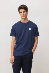 Remera de manga corta color azul marino, con cuello redondo y pequeño logo de cruz blanca estampado en el pecho.