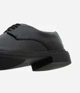 Zapato masculino estilo Oxford, color negro, con punta redonda y cierre de cordones. Posee suela robusta de goma.
