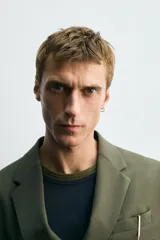 Blazer de corte regular fit confeccionado en tejido ligero con lana. Presenta cuello con solapas de muesca, cierre frontal de botonadura cruzada, mangas largas con botones en los puños, bolsillos de vivo en el pecho y bolsillos de solapa en la cadera.