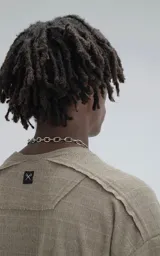 Remera de manga corta y cuello redondo, color verde militar, confeccionada en algodón premium con textura de tejido a rombos. Presenta un calce regular con recortes deshilachados en los hombros.