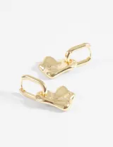 Par de aros tipo argolla dorados con dije colgante de corazón con textura martillada o machacada.