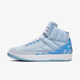 Championes Air Jordan 2 en colaboración con J Balvin, de caña alta en color celeste. Presentan paneles acolchados tipo puffer con diseño cuadriculado, gráficos de nubes en el talón, costuras en varios colores y suela translúcida.
