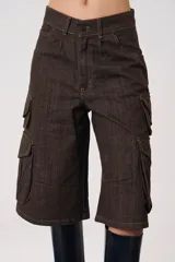 Bermuda cargo de tiro medio confeccionada en denim color marrón oscuro. Presenta un diseño amplio con bolsillos laterales tipo cargo con solapa y bolsillos delanteros clásicos, cierre frontal con cremallera y botón.
