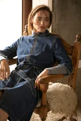 Trench de jean elastizado azul con cierre delantero, frunce en la cintura y lazo para atar.