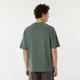 Camiseta verde con mangas raglán cortas y estampado con el texto "[NXT-K] NO LIMITS. NO HESITATIONS" en el pecho.