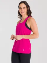 Remera deportiva sin mangas color fucsia, con cuello redondo y espalda estilo nadadora. Presenta un diseño holgado con un pequeño logo estampado en la parte inferior.