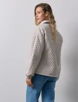 Campera beige capitoneada con capucha, cierre frontal y bolsillos laterales.