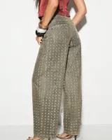 Pantalón de jean gris con tachas plateadas, corte recto y tiro alto.