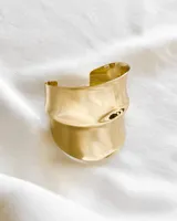 Pulsera rígida dorada con forma irregular.