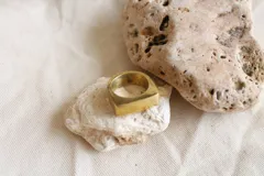 Anillo sello dorado de bronce con forma cuadrada.