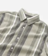Camisa de hombre de manga corta con cuello tradicional y abotonado frontal. Presenta un tejido texturizado con un patrón de rayas verticales en tonos beige, blanco y marrón claro.