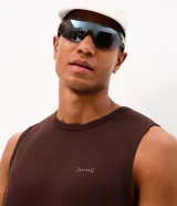 Musculosa deportiva marrón con cuello redondo, confeccionada con tecnología Dry y tejido de modal, poliéster y elastano. Presenta una pequeña estampa minimalista en el pecho.