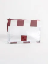 Bolso tipo tote grande, resistente al agua, con diseño de rayas verticales rojas y blancas. Cuenta con asas largas de hombro, cierre superior y parche de cuero con logo grabado. Incluye neceser transparente a juego con base y detalles a rayas.