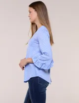 Blusa celeste con estampado de lunares blancos, cuello en V y mangas 3/4 terminadas en volados.