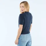 Sweater de punto azul marino con cuello en V, manga corta y cierre frontal con tres botones dorados en forma de concha.