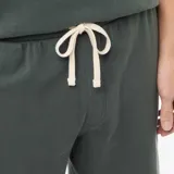 Conjunto de pijama de dos piezas compuesto por una remera de manga corta con cuello redondo y un short con cintura elástica, confeccionado en tejido de textura nido de abeja color verde oscuro.