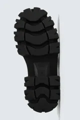 Zapato de vestir estilo derby color negro, con parte superior lisa, horma redonda y suela track con volumen.