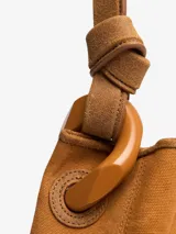 Bolso marrón de algodón y cuero, tipo bucket, con asa superior fija con eslabón metálico y cierre interno con botón a presión.