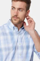 Camisa celeste y blanca a cuadros, de corte clásico, con cuello abotonado y manga larga.