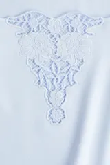 Top corto celeste de punto suave con escote cuadrado amplio y bajo recto. Modelo de manga corta con ajuste entallado y detalle en V en broderie en el centro del busto.