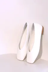 Ballerinas doradas con punta redondeada y suela plana color madera.