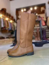 Botas altas de montar de cuero color marrón, con diseño plano y suela de goma.