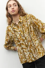 Camisa color ocre con estampado floral blanco, de manga larga, con botones de nácar y bordados a contratono.