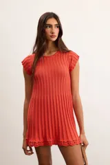 Vestido corto de punto acanalado color naranja, de manga corta y cuello redondo, con detalle de terminación en crochet en el ruedo.