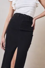 Falda midi de jean negro con tiro alto y abertura frontal.