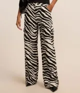 Pantalón wide de sarga con estampado animal print de cebra, cintura con trabilla, cierre tradicional y bolsillos cargo laterales.