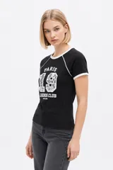 Remera de algodón blanca de manga corta estilo ringer, con cuello y puños en contraste negro. Presenta un estampado frontal con el número '28' relleno de encaje y la inscripción 'San Francisco Sports Club'.