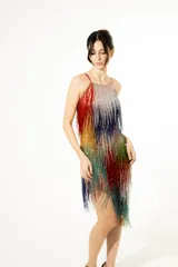 Vestido mini de flecos bordados en degradé multicolor con destellos brillantes, escote halter y silueta liviana.