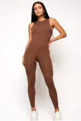 Mono deportivo largo de una pieza, color marrón, con cuello redondo alto y diseño sin mangas. Confeccionado en tejido de poliamida con efecto modelador y ajuste de compresión media.