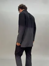 Camisa de lana color gris con cuello mao, corte recto y mangas largas con detalle texturizado. Presenta cierre invisible en el escote superior y tajos laterales.