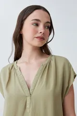 Blusa verde oliva de lyocell con cuello en V y mangas cortas.