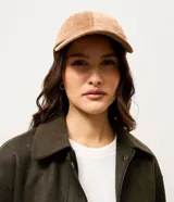 Gorra de béisbol con ala curva, confeccionada en material sintético con textura de gamuza. Cuenta con ajuste en la parte trasera.