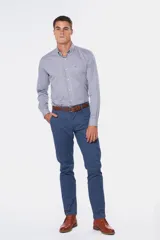 Pantalón de gabardina color marrón claro, corte slim fit, con bolsillos laterales y traseros. Se ajusta a la cintura con cinturón de cuero marrón.