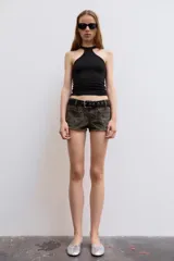 Shorts de denim de tiro bajo con estampado animal print, bolsillos de parche en el delantero, trabillas para cinto y cierre frontal con cremallera y botón metálico.