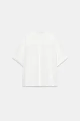 Camisa de cuello solapa y manga corta con dobladillo, presenta bolsillos de plastrón en el frente, bajo asimétrico y cierre frontal con botones ocultos.