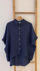 Camisa verde militar de lino italiana con botones de nácar, corte holgado, cuello camisero y mangas cortas con dobladillo.