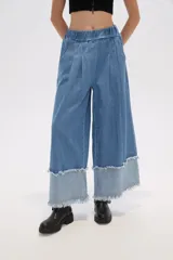 Pantalón de jean azul de corte ancho y tiro alto, con bolsillos y pinzas.