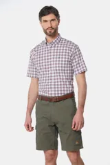 Bermuda cargo color beige con bolsillos laterales y traseros. Se ajusta a la cintura con cinturón de cuero marrón.