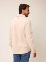 Sobrecamisa de polar azul marino con cierre frontal de botones a presión. Presenta bolsillos frontales con solapa, uno de ellos con cierre de cremallera adicional y detalles en contraste de material técnico.