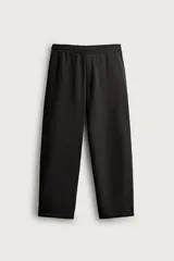Pantalón jogger de corte relajado y pernera ancha, confeccionado en tejido de algodón con interior perchado. Cuenta con cintura elástica ajustable mediante cordón interior, bolsillos laterales y un bolsillo trasero de plastrón.