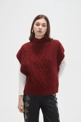 Chaleco de punto con diseño de ochos, cuello alto y corte holgado.
