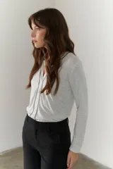 Remera manga larga color borgoña con cuello en V y costuras decorativas verticales.