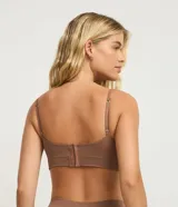 Soutien top femenino color marrón, confeccionado en poliamida sin costuras, con escote en V, breteles finos ajustables y copas. Cierre con ganchos y ojales en la espalda.