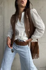 Blusa blanca de mangas largas abullonadas con puños elásticos y detalles de encaje y bordados sutiles. Presenta escote en V con tiras decorativas y diseño holgado.