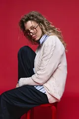 Sweater de tejido de punto negro con tramas de ochos en las mangas y laterales, cuello redondo a la base y mangas largas.