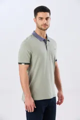 Remera polo de manga corta en color índigo con cuello y botones en contraste. Presenta detalles de color en los puños, aportando un toque sutil y moderno.